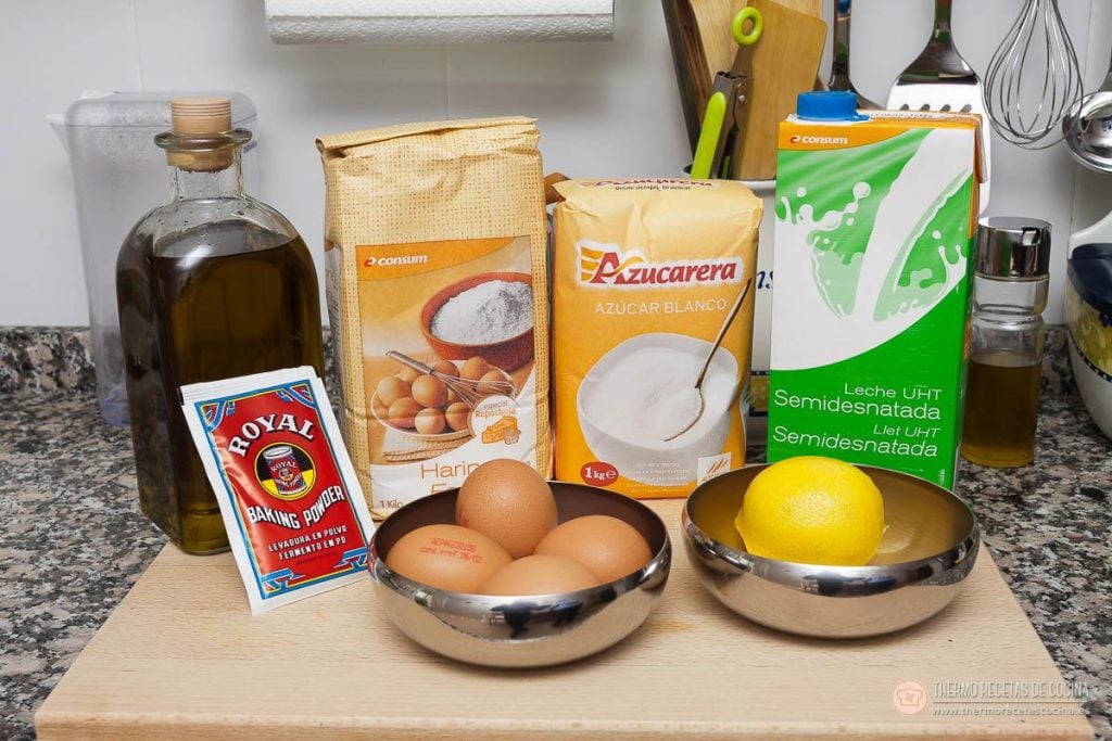 Ingredientes de la coca de llanda sobre la encimera: aceite de oliva, un sobre de levadura Royal, harina, azúcar, leche semidesnatada, tres huevos y un limón