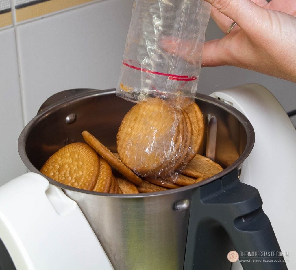 Galletas maría doradas cayendo desde el paquete al vaso de la Thermomix para triturarlas