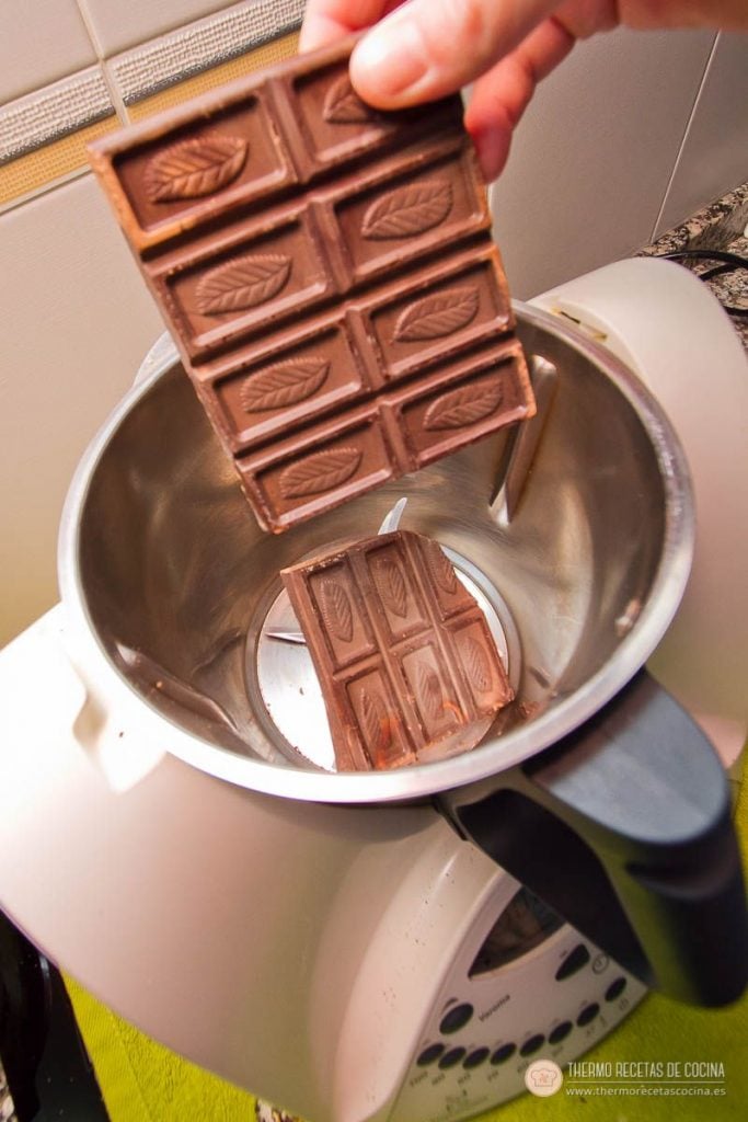 Tableta de chocolate de fundir partida, cayendo dentro del vaso de la Thermomix