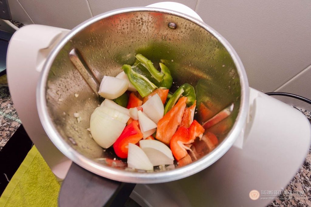 Pollo al chilindrón | 4 | Thermo Recetas Cocina Cebolla, pimiento rojo y pimiento verde en trozos grandes dentro del vaso, sobre el sofrito de ajo