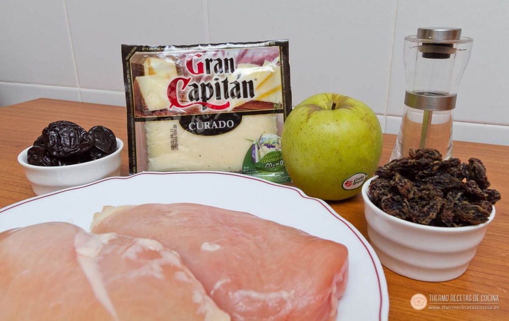 Ingredientes de la pechuga rellena: dos pechugas de pollo, un paquete de queso curado en lonchas, una manzana golden, un cuenco de ciruelas pasas y otro de uvas pasas