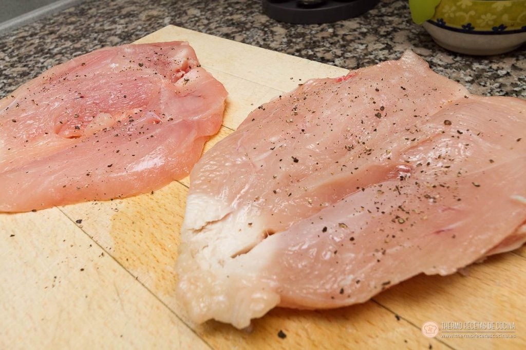 Las dos pechugas de pollo abiertas en libro, salpimentadas y listas para rellenar