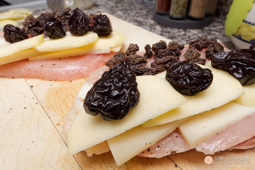 Relleno de manzana en láminas, queso, ciruelas pasas y uvas pasas colocado sobre la pechuga antes de enrollar
