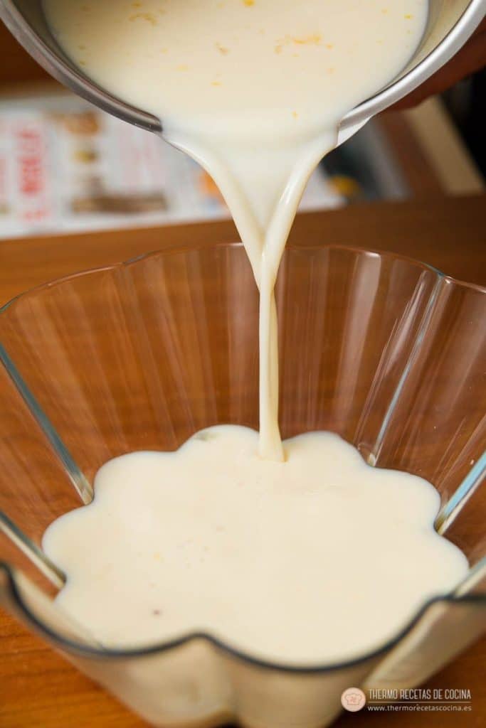 Mezcla líquida del flan cayendo desde el vaso de la Thermomix al molde acanalado ya caramelizado