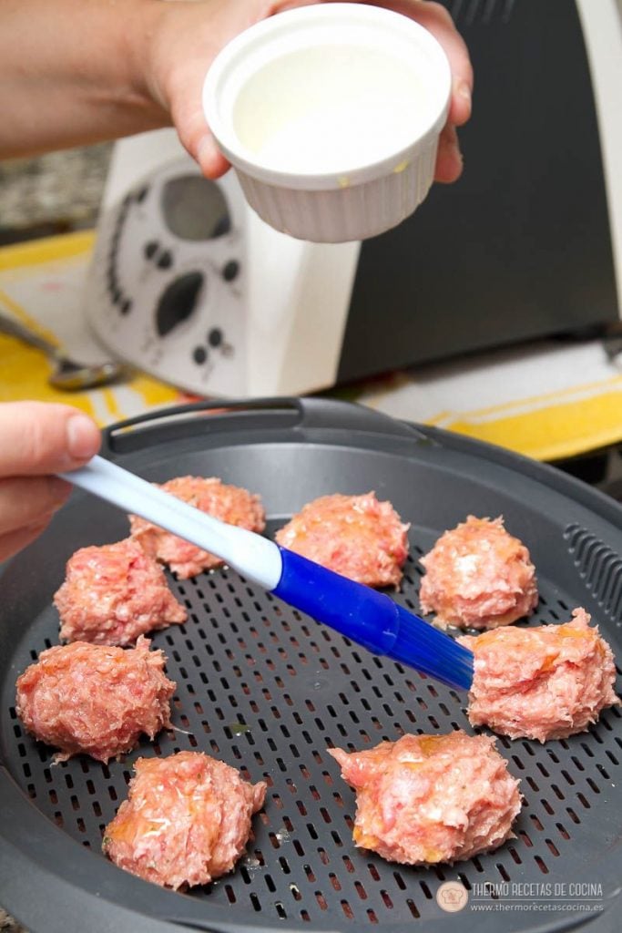 Albóndigas en salsa de tomate en Varoma | 8 | Recetas de cocina para Thermomix Albóndigas crudas repartidas separadas en la bandeja del Varoma, pincelándolas con aceite de oliva