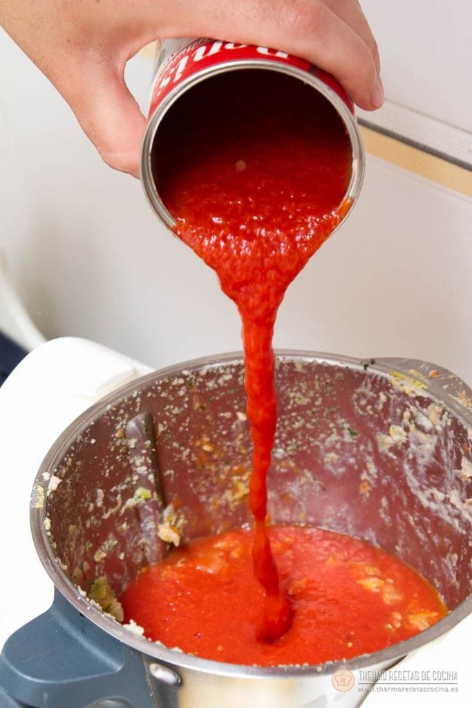Albóndigas en salsa de tomate en Varoma | 9 | Recetas de cocina para Thermomix Tomate natural triturado vertiéndose desde la lata dentro del vaso con el sofrito ya hecho