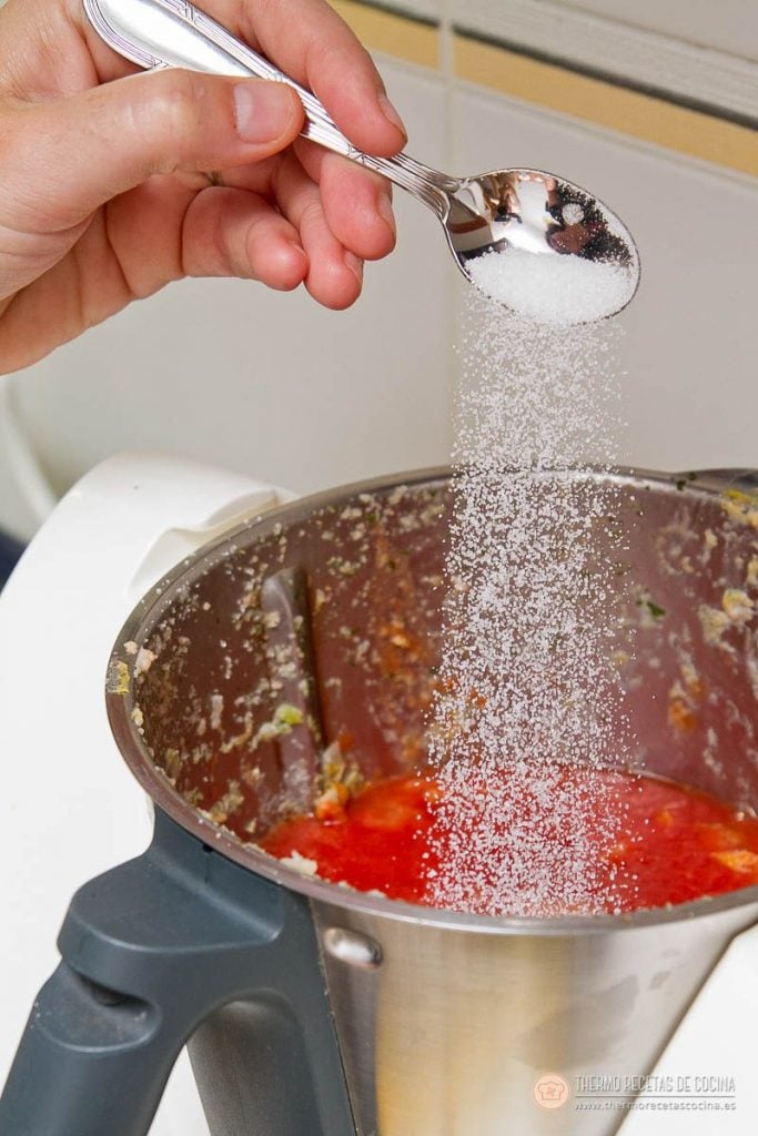 Albóndigas en salsa de tomate en Varoma | 10 | Recetas de cocina para Thermomix Una cucharadita de azúcar cayendo sobre el tomate triturado en el vaso, con el sofrito pegado en las paredes