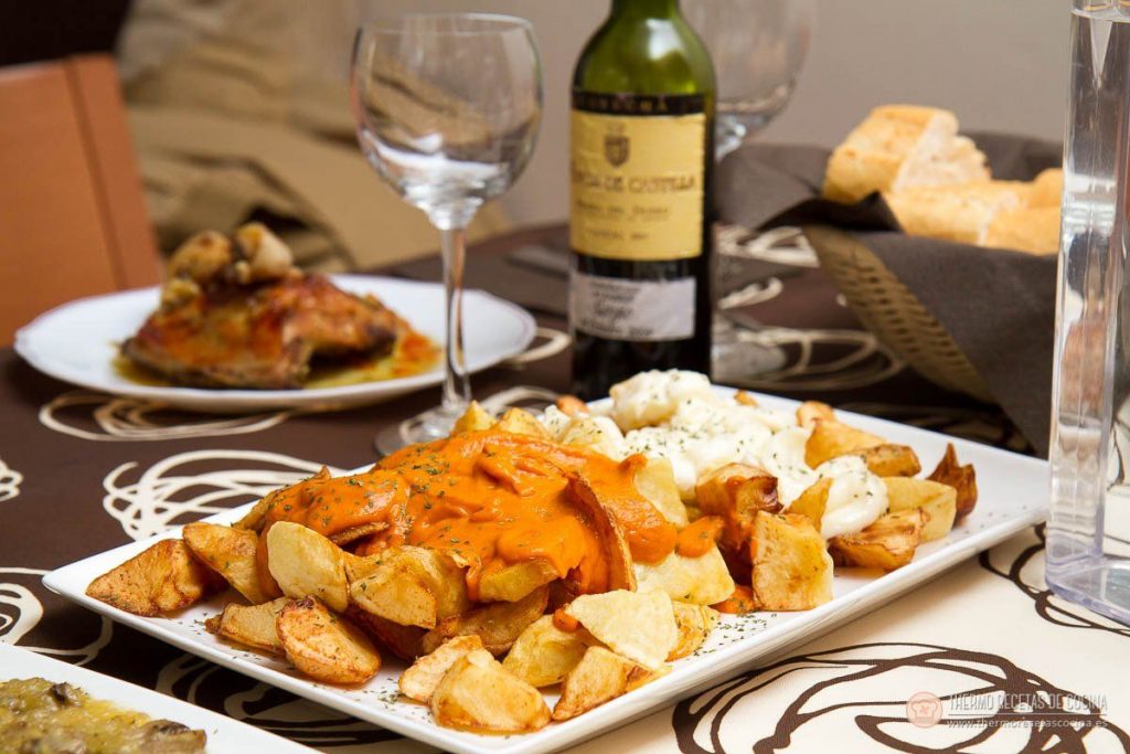 Salsa brava en thermomix | 5 | Thermo Recetas Cocina la mesa puesta con la fuente de patatas bravas, el alioli y el resto de la comida