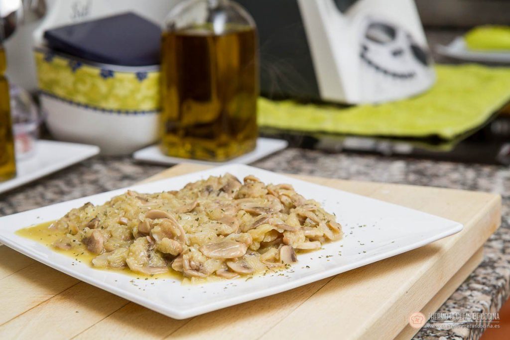 los champiñones ya cocinados con su salsa, servidos en un plato cuadrado y espolvoreados con perejil