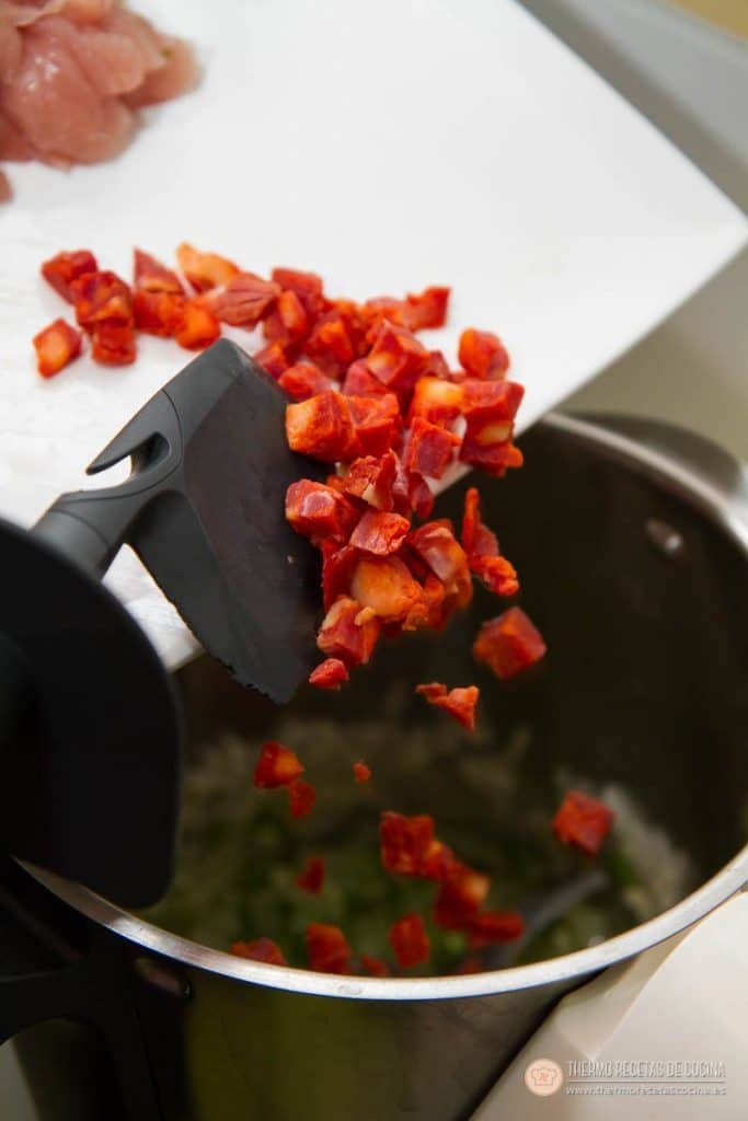Arroz con pollo y chorizo | 8 | Recetas de cocina para Thermomix Dados de chorizo cayendo desde la tabla al vaso, sobre el sofrito de cebolla y pimiento