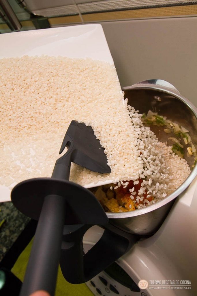 Arroz con pollo y chorizo | 11 | Recetas de cocina para Thermomix Arroz vertiéndose desde el plato dentro del vaso, sobre el sofrito de pollo y chorizo