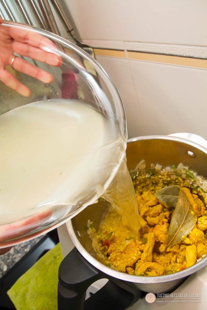 Arroz con pollo y chorizo | 12 | Recetas de cocina para Thermomix Caldo vertiéndose dentro del vaso sobre el arroz, el pollo y el chorizo ya coloreados de amarillo