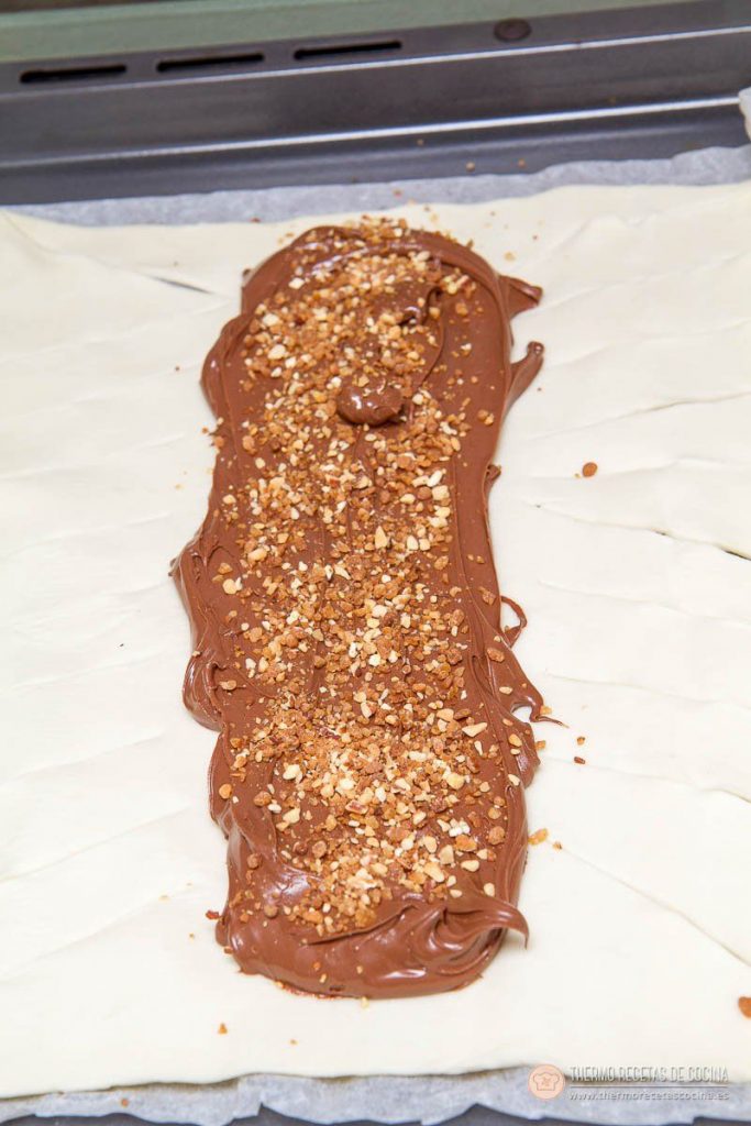 Trenza de crema de hojaldre y crema de cacao | 5 | Thermo Recetas Cocina nutella extendida en la franja central del hojaldre y cubierta de crocanti de almendra, con las tiras laterales ya cortadas