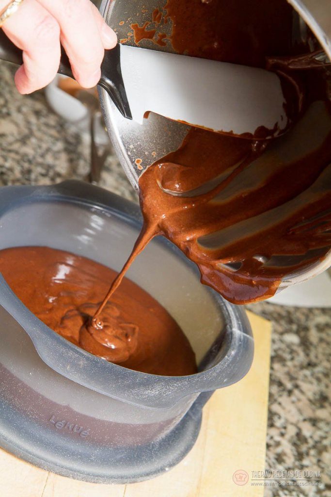 Bizcocho Chocolate y Canela | 5 | Thermo Recetas Cocina Vertiendo la masa de chocolate con la espátula desde el vaso de la Thermomix a un molde redondo de silicona