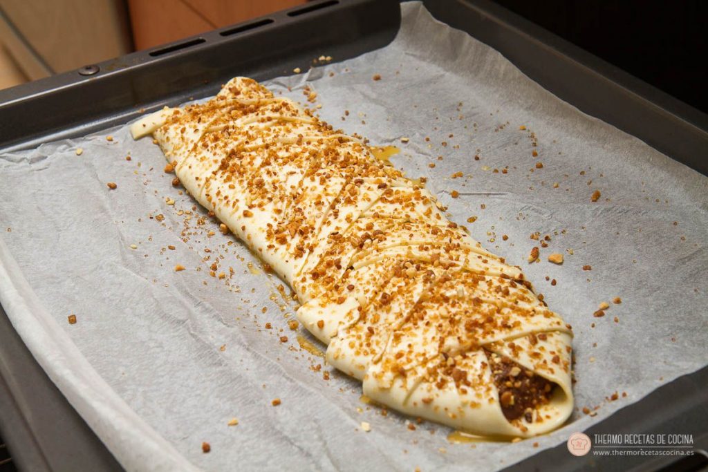 Trenza de crema de hojaldre y crema de cacao | 6 | Thermo Recetas Cocina trenza de hojaldre cruda ya trenzada, pintada con huevo y cubierta de azúcar moreno y crocanti de almendra sobre el papel de horno