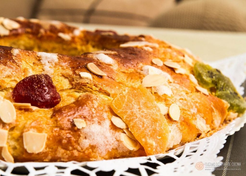 Roscón de Reyes | 2 | Thermo Recetas Cocina roscón de Reyes thermomix recién horneado sobre una blonda, con almendra fileteada, azúcar humedecida y fruta escarchada roja y verde