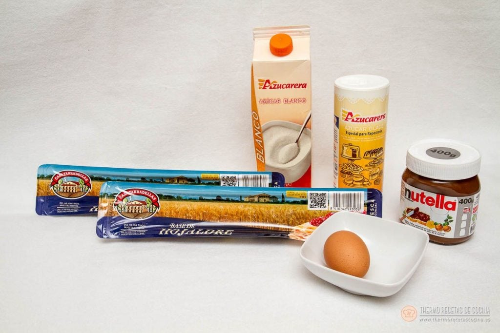 Árbol de Navidad de Nutella y hojaldre | 3 | Thermo Recetas Cocina ingredientes del árbol de Navidad: dos rollos de base de hojaldre, un bote de nutella de 400 g, azúcar blanco, azúcar glacé y un huevo en un cuenco