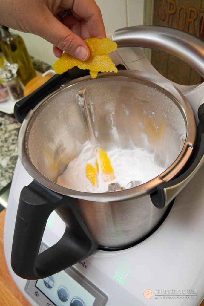 Marquesas | 5 | Thermo Recetas Cocina añadiendo tiras de piel de limón al azúcar ya pulverizado dentro del vaso de la Thermomix