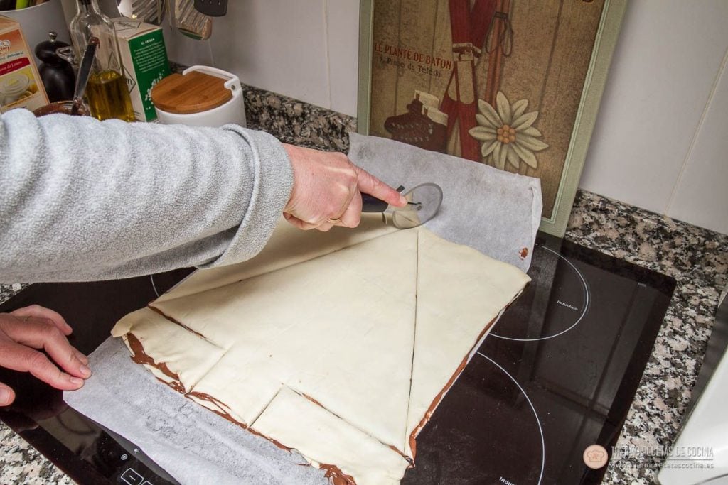 Árbol de Navidad de Nutella y hojaldre | 6 | Thermo Recetas Cocina recortando con un cortapizzas la forma triangular del árbol sobre las dos planchas de hojaldre