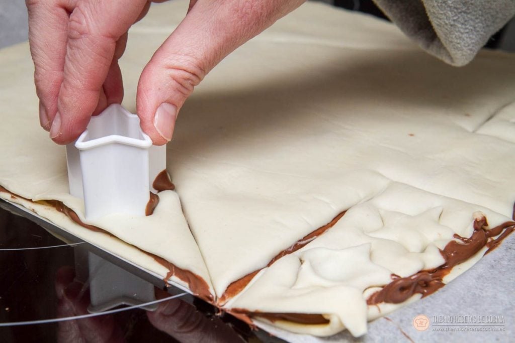 Árbol de Navidad de Nutella y hojaldre | 7 | Thermo Recetas Cocina cortapastas con forma de estrella marcando el hojaldre sobrante que rodea al árbol