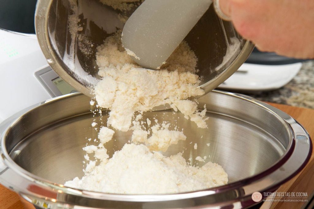 Marquesas | 7 | Thermo Recetas Cocina vaciando con la espátula la mezcla de almendra, harina, maicena y levadura del vaso a un bol metálico