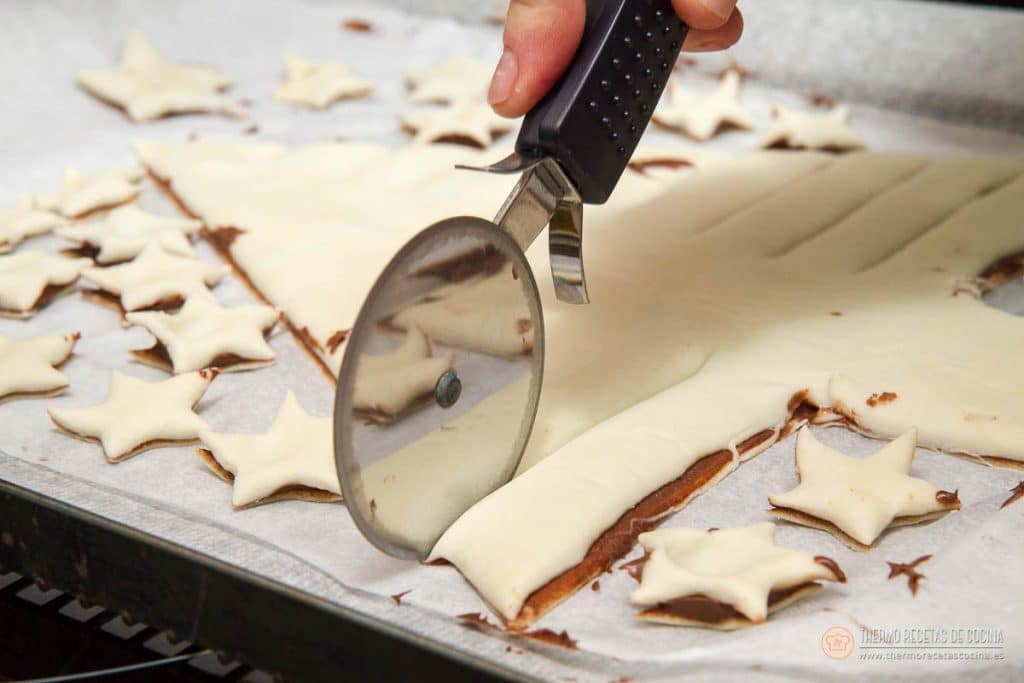 Árbol de Navidad de Nutella y hojaldre | 9 | Thermo Recetas Cocina cortando con el cortapizzas tiras en diagonal a un lado del árbol para formar las ramas