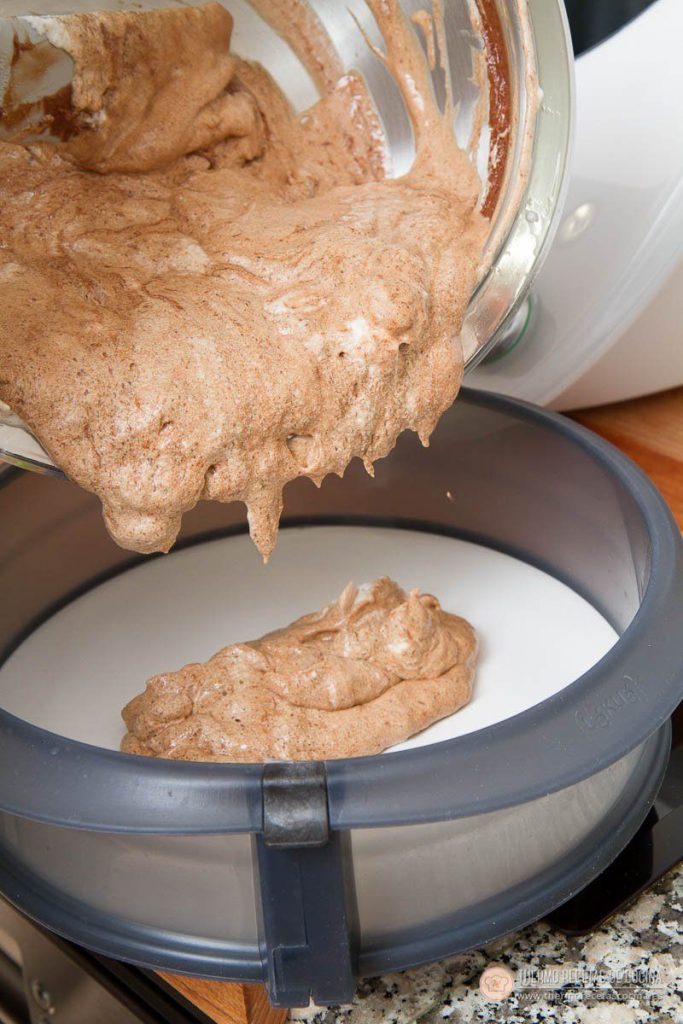 Masa aireada de bizcocho de chocolate vertiéndose en un molde desmontable