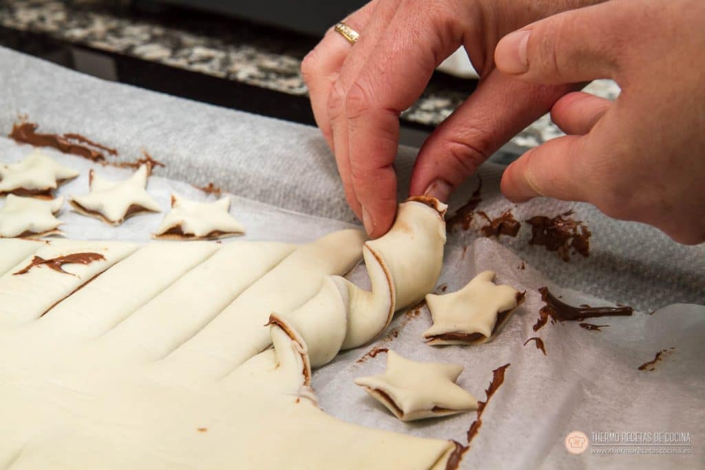 Árbol de Navidad de Nutella y hojaldre | 10 | Thermo Recetas Cocina retorciendo a mano una tira de hojaldre en espiral para formar una rama del árbol