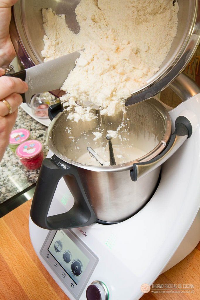 Marquesas | 9 | Thermo Recetas Cocina volcando con la espátula la mezcla seca de almendra desde el bol al vaso, sobre los huevos ya montados