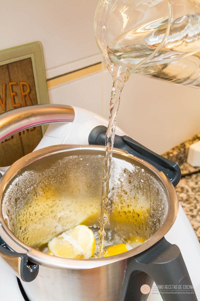 agua fría cayendo en el vaso de la Thermomix sobre los limones ya troceados
