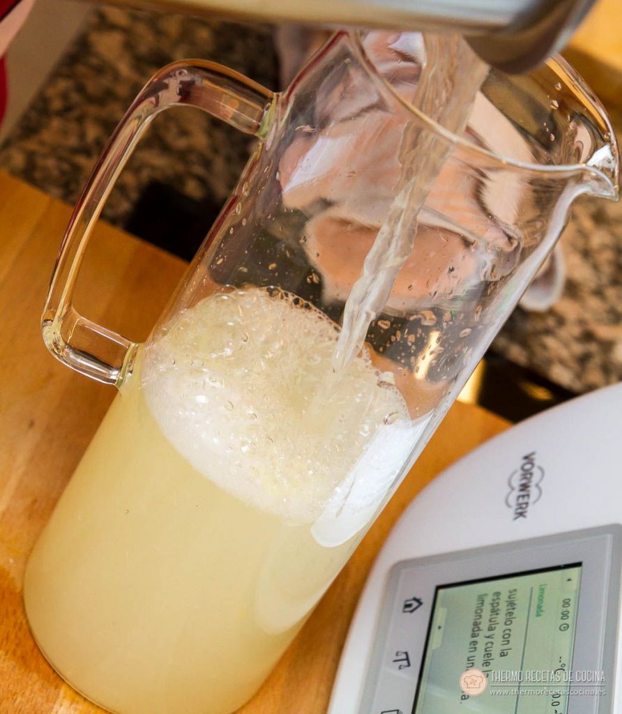 la limonada cayendo del vaso a una jarra de cristal, con la capa de espuma que hace al servir