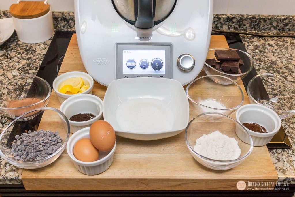 Cookies brownie de chocolate | 3 | Recetas de cocina para Thermomix ingredientes de las cookies brownie repartidos en cuencos delante de la Thermomix: cacao, mantequilla, café soluble, azúcar, huevos, perlas de chocolate, chocolate en trozos y harina