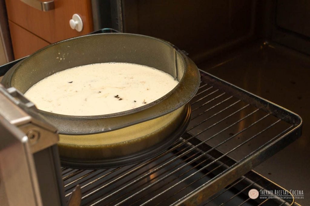 Molde redondo desmontable con la mezcla de queso y los trozos de turrón, colocado en la rejilla del horno